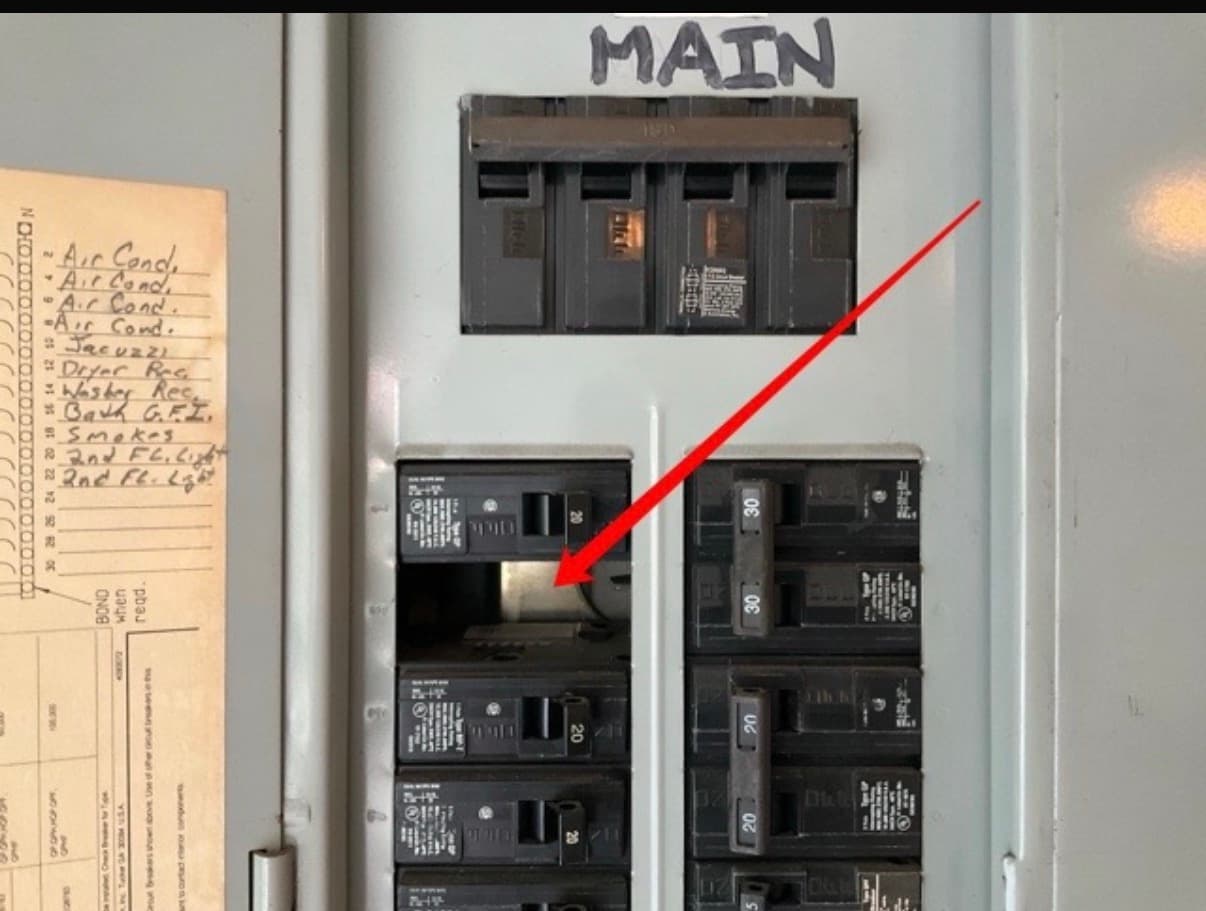 Main electrical panel with an open breaker slot exposing the energized bus, flagged during a home inspection